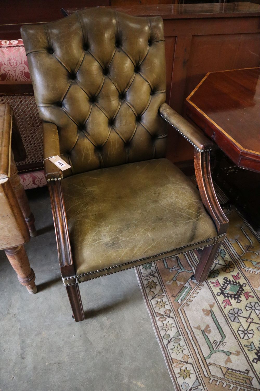 A George III style mahogany library chair, upholstered in buttoned green leather, width 58cm height 100cm